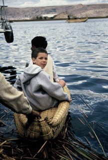 boy riding out in boat in Puno, Peru