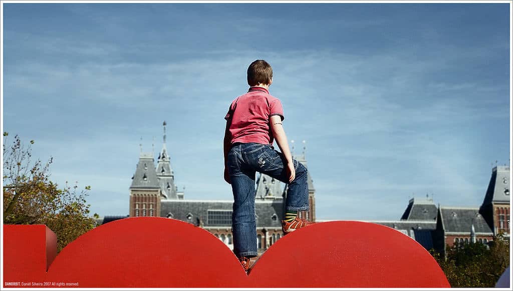 Young boy on top of Amsterdam letters