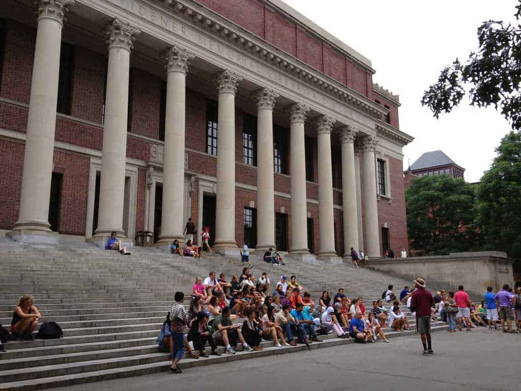 Harry Elkins Widener Memorial Library, photo from 2012, showing a group of tourists sitting on the steps of the library, listening to The Hahvahd Tour guide that may or may not still be at Harvard