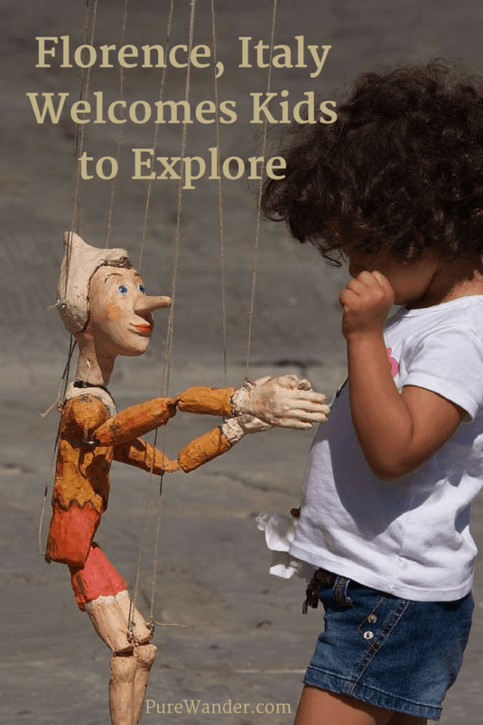 Child plays with a puppet in Florence, Italy
