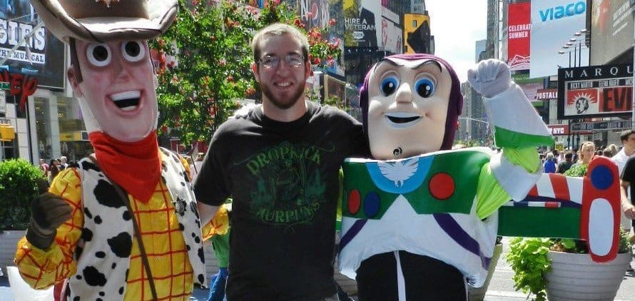 man posing with Buzz and Woody in Times Square
