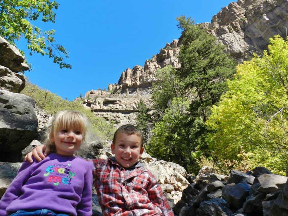 two kids sitting on the trail at Hanging Lake in Glenwood Springs, Colorado