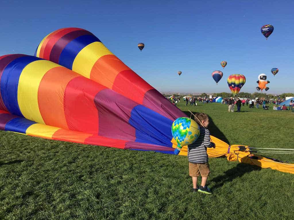 boy watching balloon being put away at Albuquerque Balloon Fiesta