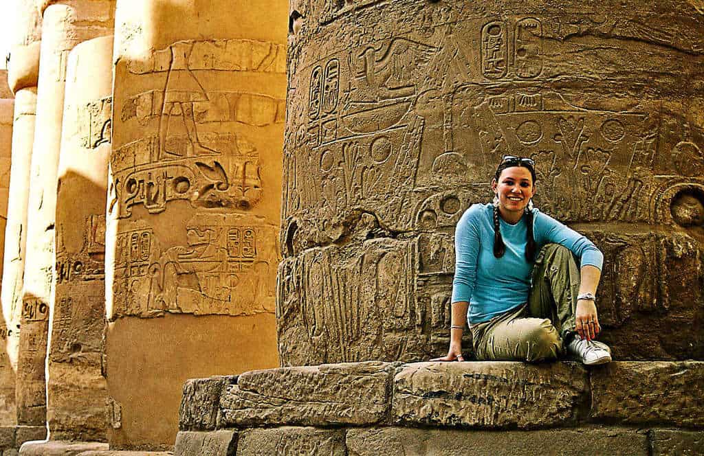 pigtailed girl sitting near ancient egyptian ruins in egypt