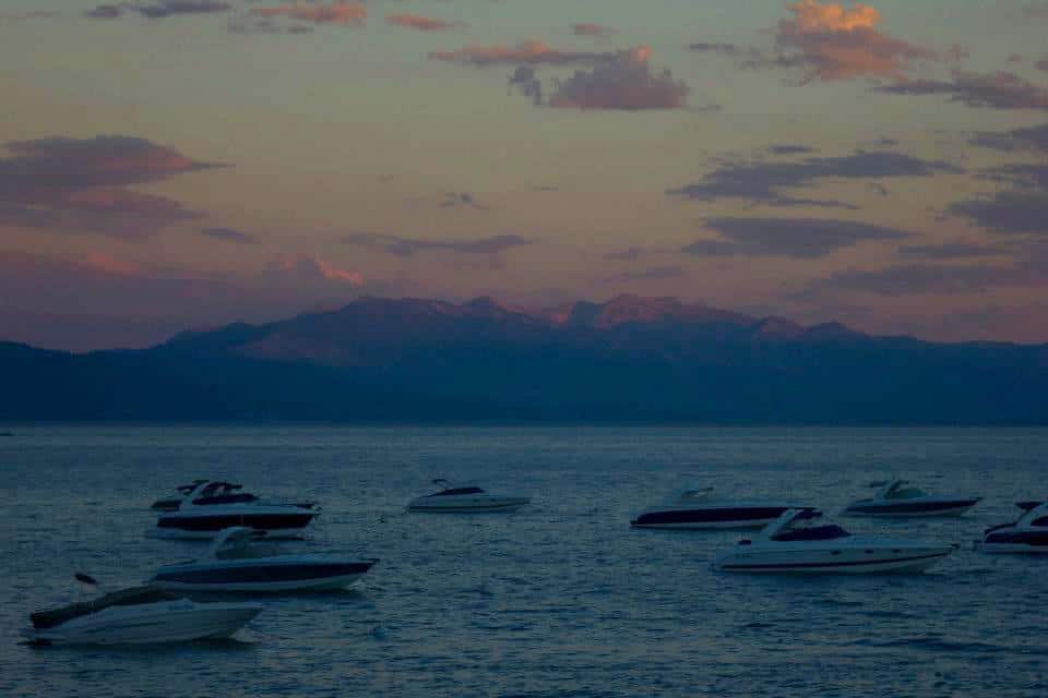 boats floating on lake tahoe during sunset