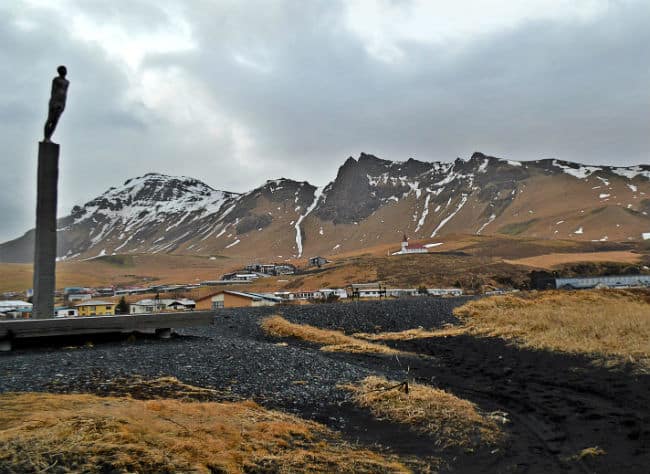statue near vik in iceland with mountains and black sand
