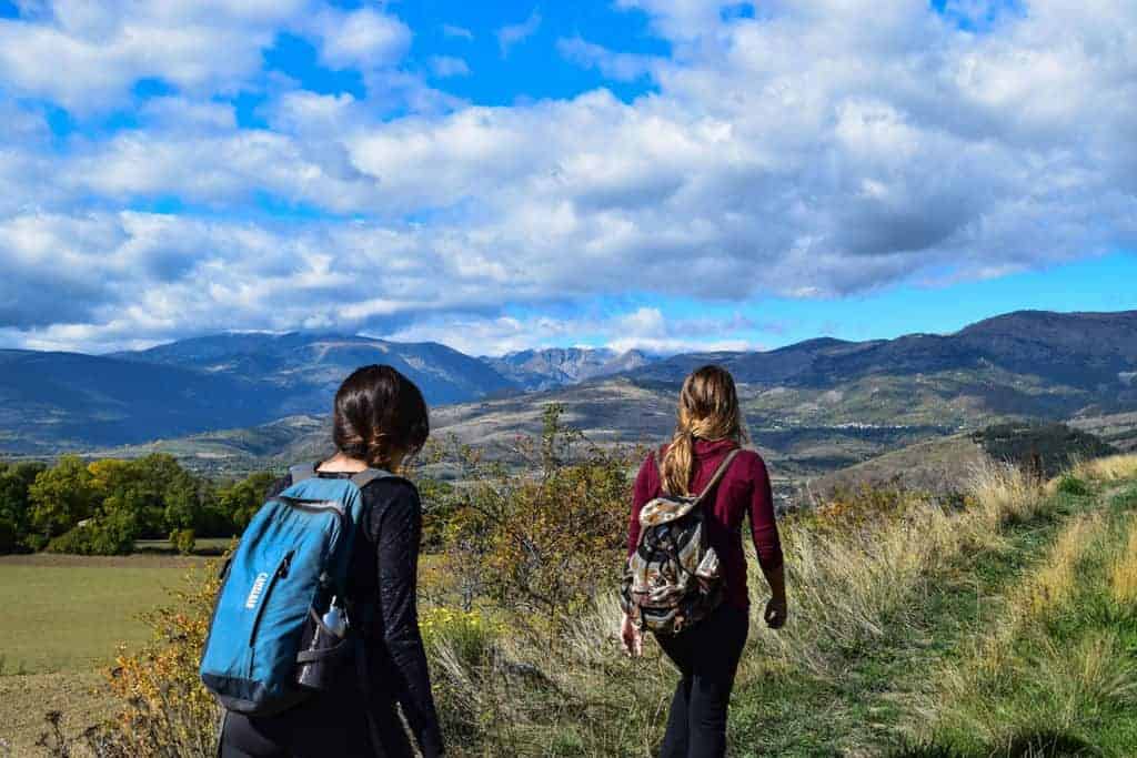 two women hiking with backpacks