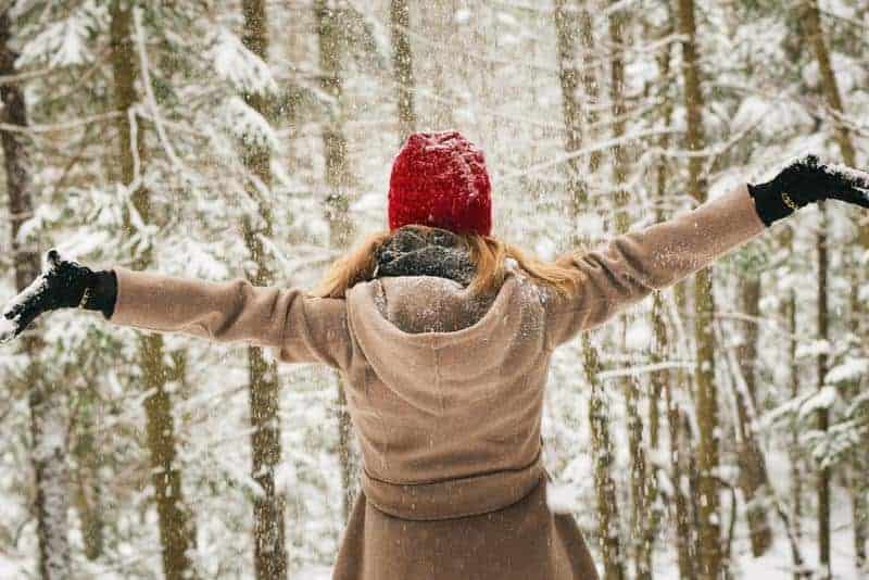 woman outside in the snow with red hat