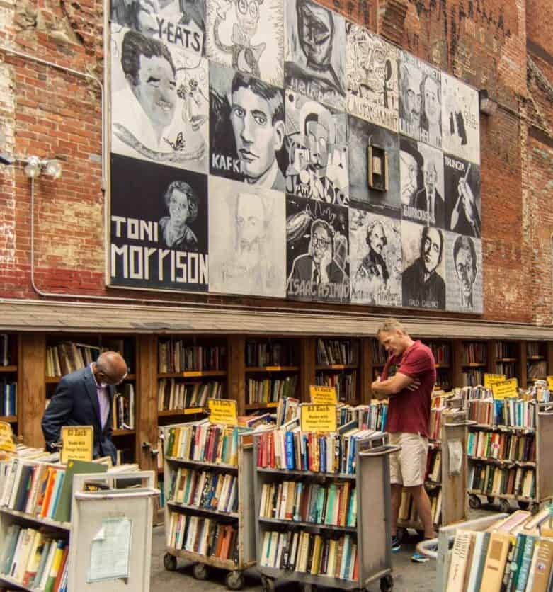 breattle book shop fron with carts of books and mural