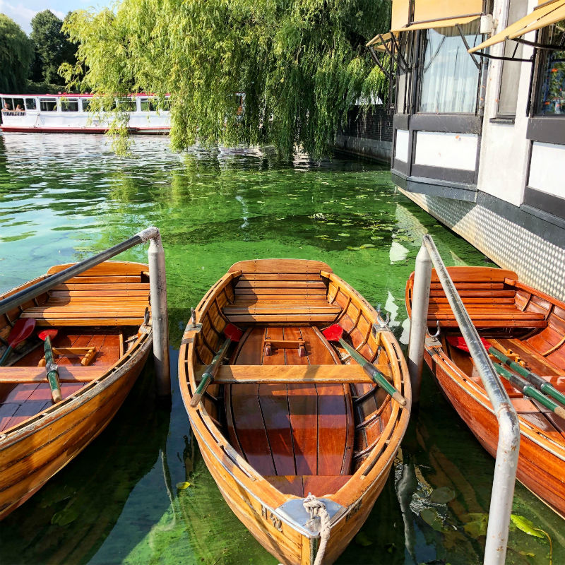 three empty canoes on canal in hamburg germany