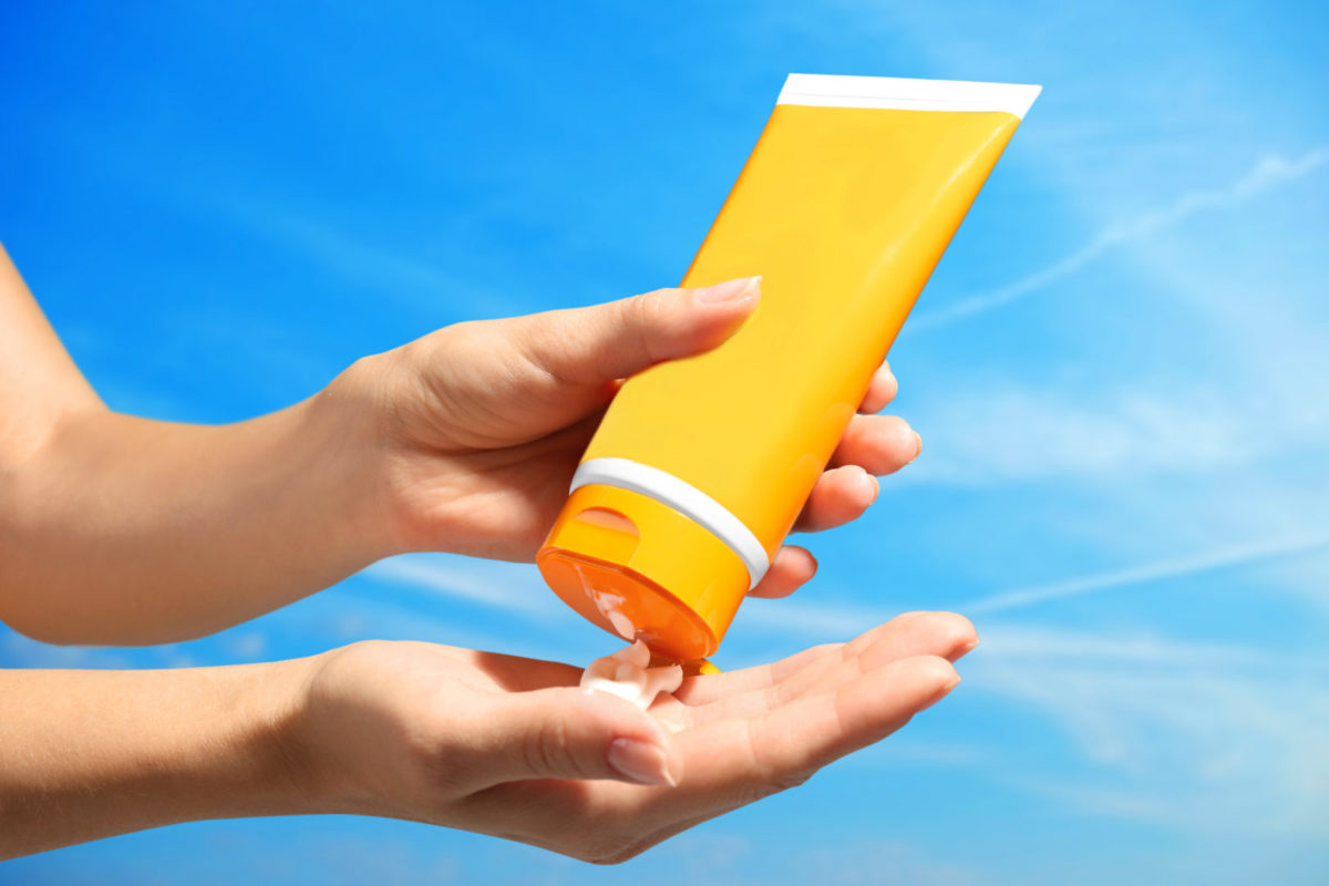 sunscreen in yellow container with blue sky background