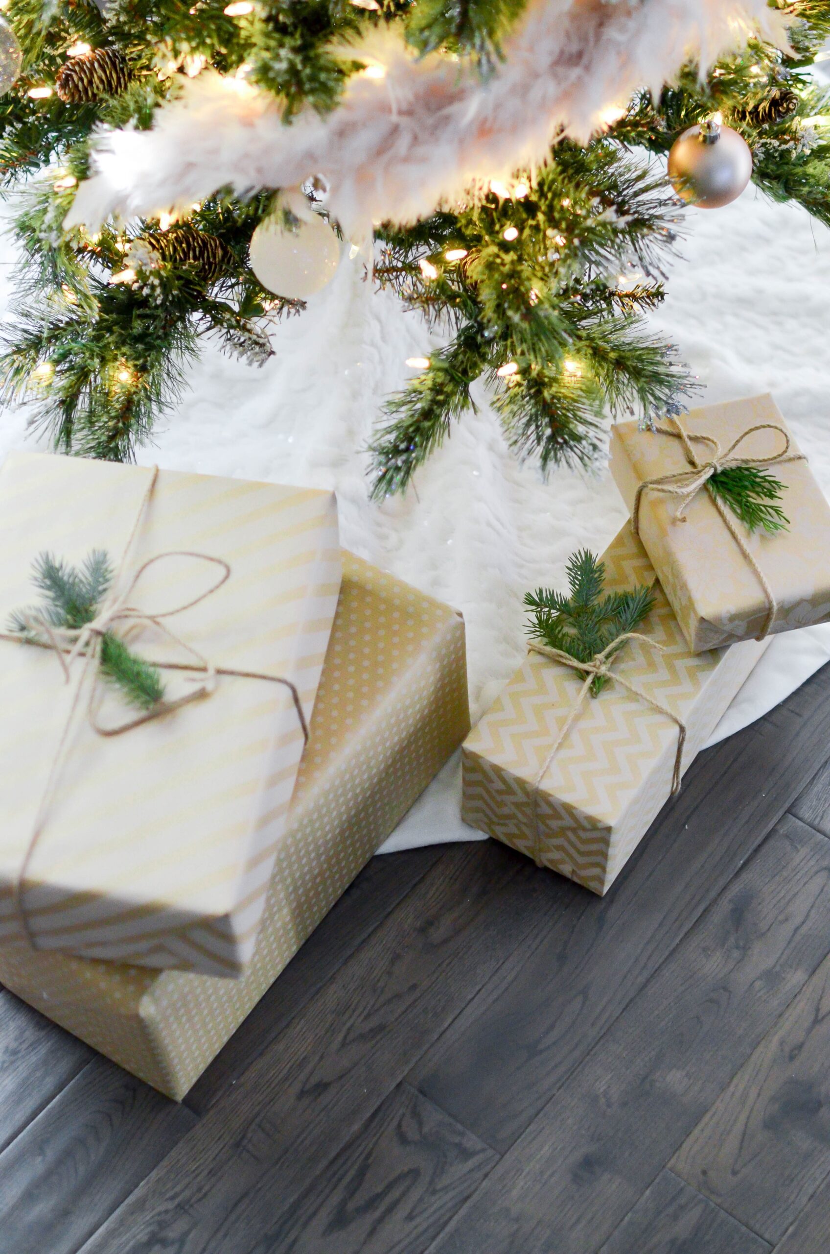 brown wrapped gifts under a holday tree with white lights