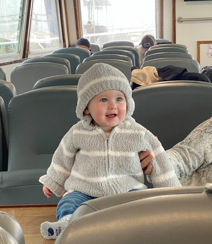 baby in grey sweater on empty captian john boat