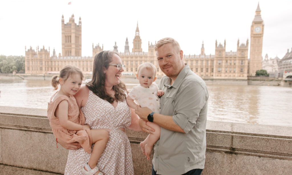 laughing family in front of parliament building in london uk