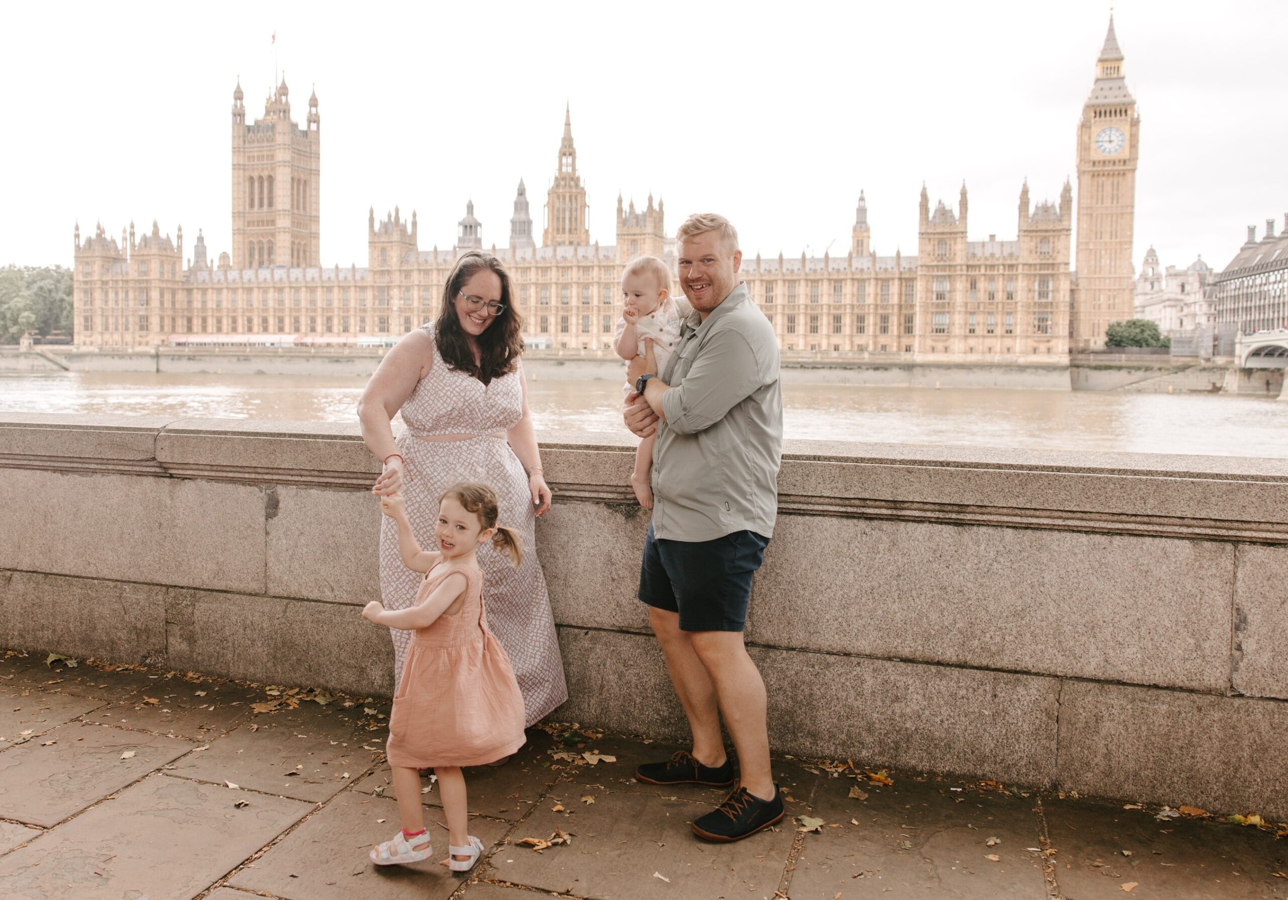 family of four in front of parliament london two young girls