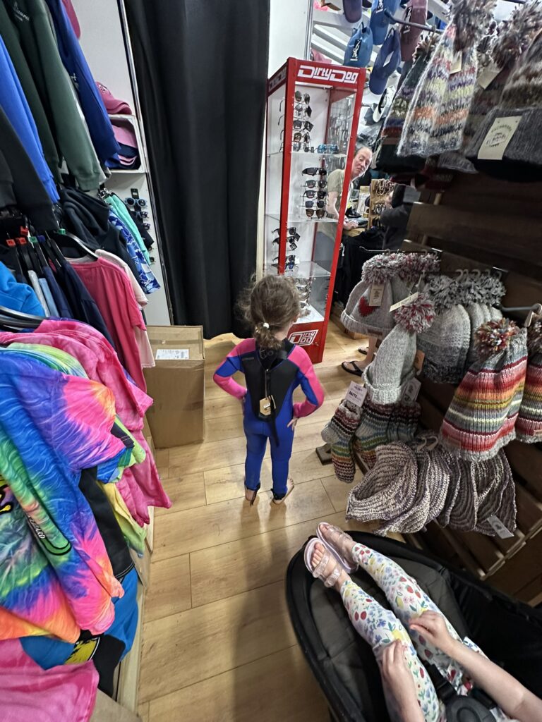 child trying out wetsuits in bude cornwall uk